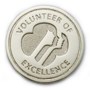 Silver Circular Pin Enscribed with 'Volunteer of Excellence' and a Trefoil
