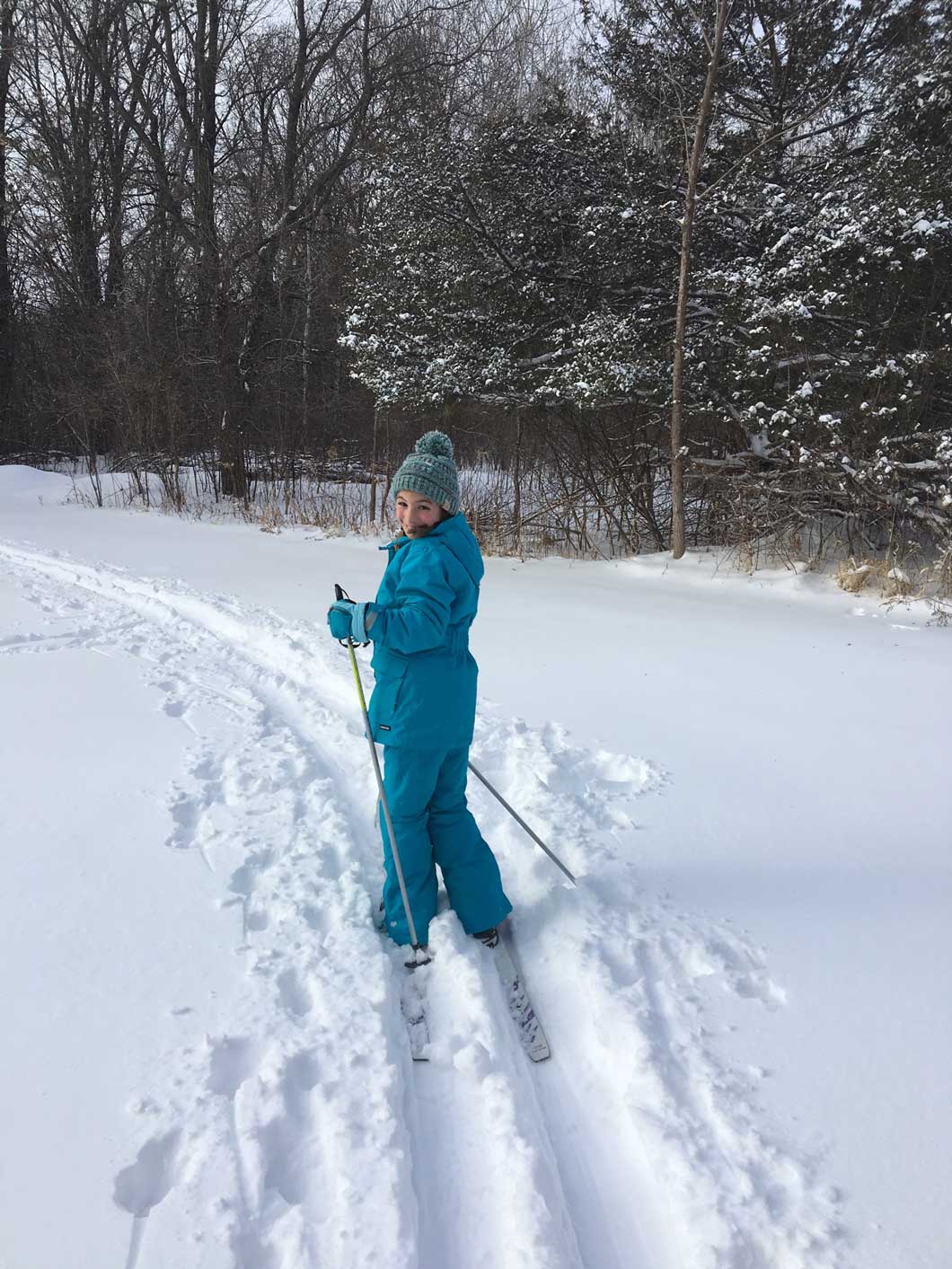 A junior Girl Scout cross country skiing.