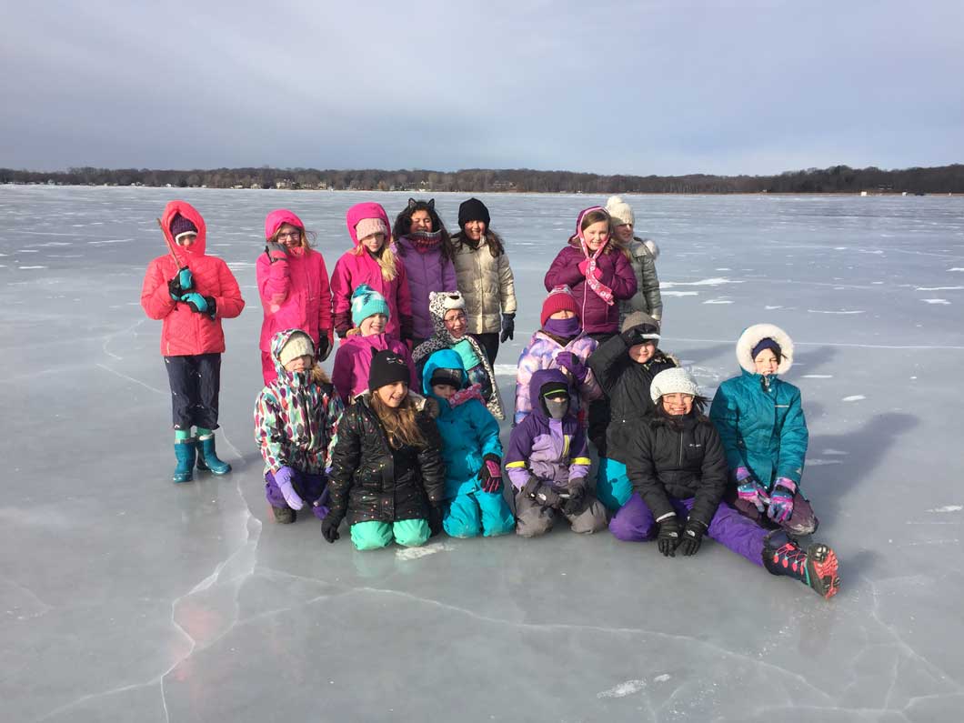 Girl Scout Troop 18102 posing for a picture in the middle of a frozen lake.